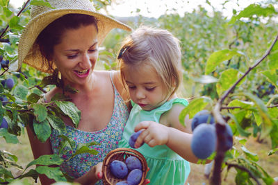 Mother and daughter picking fruits