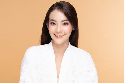 Portrait of a smiling young woman against gray background
