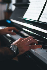 Cropped hands of man playing piano