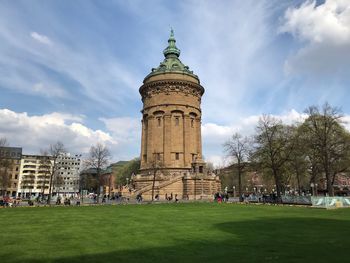 Group of people in front of historical building against sky