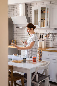 Side view of woman standing at home