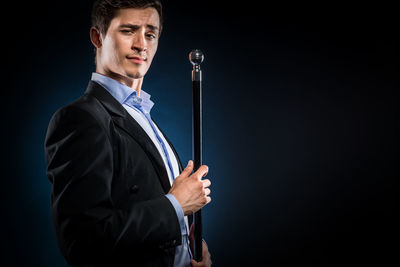 Portrait of young man against black background