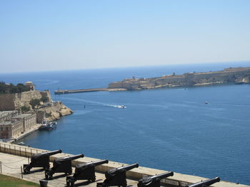 High angle view of buildings by sea against clear sky