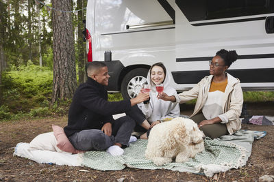 Friends relaxing in front of camper van