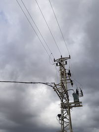 Low angle view of electricity pylon against sky