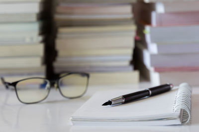 Close-up of pen on open blank book at table