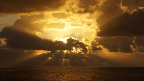 Sunset rays behind clouds