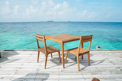 Chairs on beach against sky