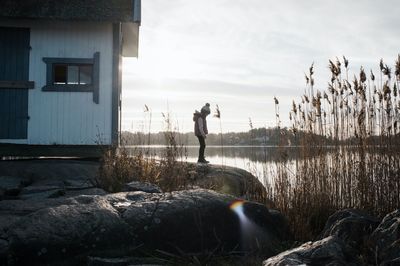 Young girl stood on the rocks next to a traditional swedish hut