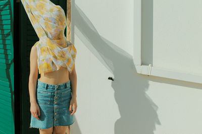 Midsection of woman standing against wall