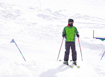 Rear view of man skiing on snowy field