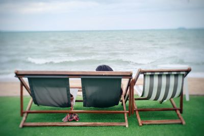 Rear view of lounge chairs on beach