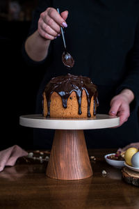 Midsection of man holding ice cream on table