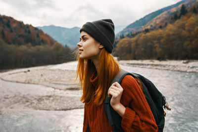 Young woman looking away while standing on mountain