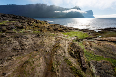 Scenic view of sea and mountains against sky