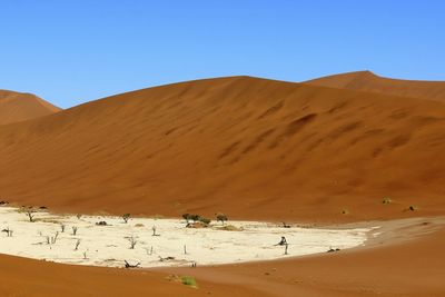 Scenic view of desert against blue sky