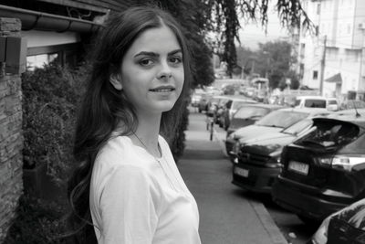 Portrait of smiling young woman standing in city