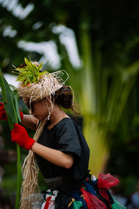 Rear view of people standing against plants