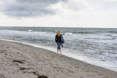 Woman walking on windy beach