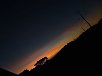 Low angle view of silhouette mountain against dramatic sky