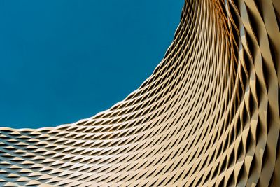 Low angle view of modern building against blue sky