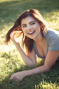 Smiling young woman lying on land