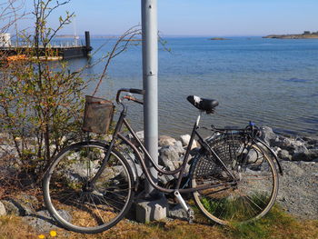 Bicycle by sea against sky