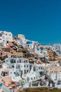 Buildings in city against clear blue sky