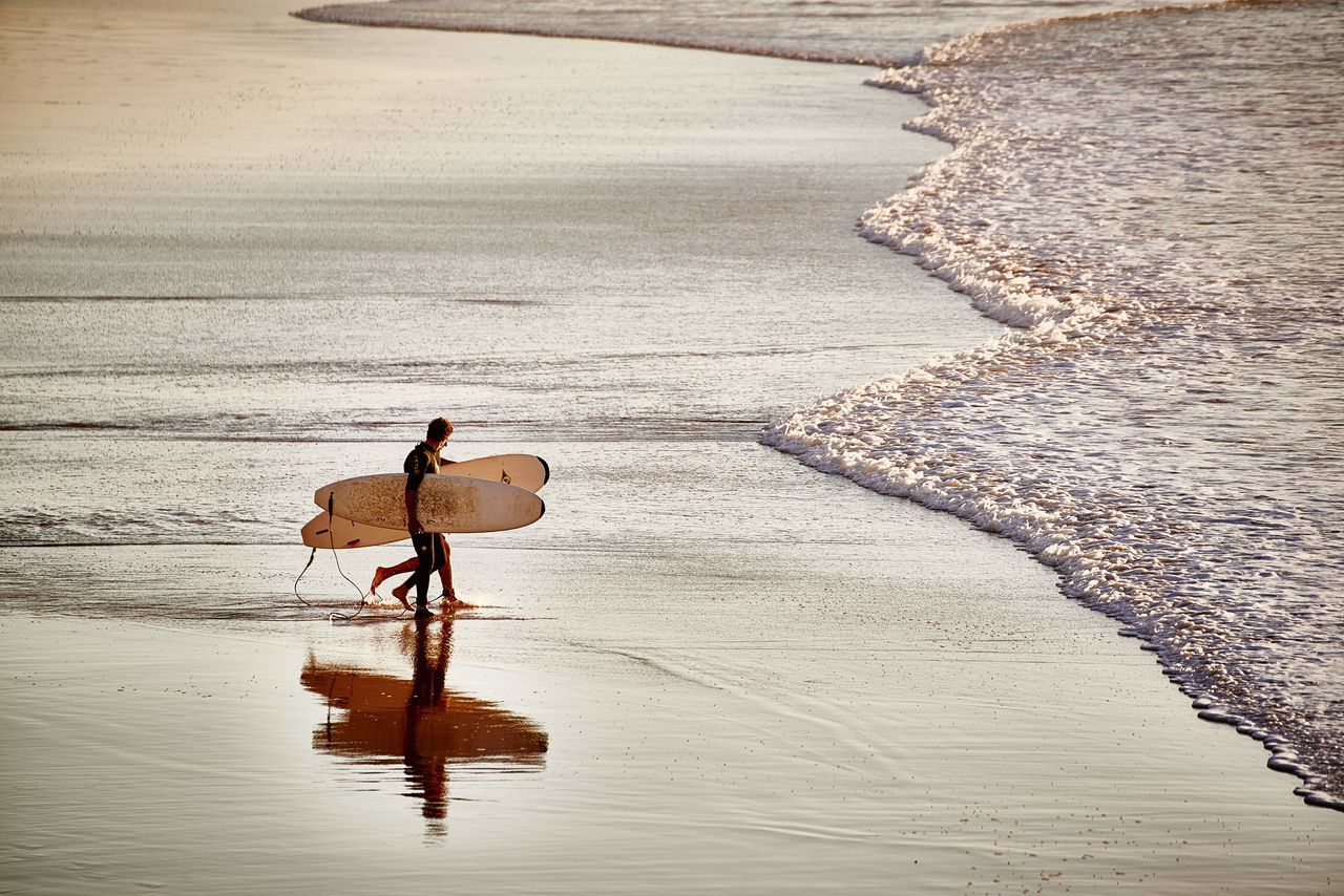 sea, beach, sand, water, leisure activity, lifestyles, men, transportation, shore, mode of transport, vacations, horizon over water, full length, tranquility, sunlight, high angle view, travel, bicycle