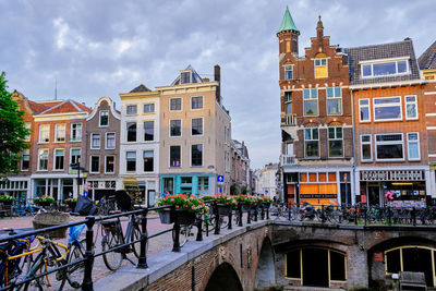 Utrecht, the netherlands. a line of bikes parked on a bridge over the oudegracht canal.