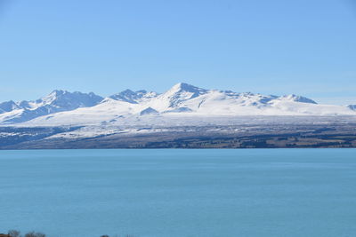 Scenic view of snowcapped mountains against blue sky