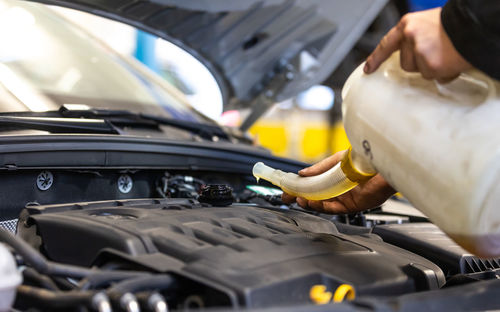 Cropped hand of man washing car