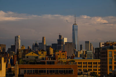 Buildings in city against cloudy sky