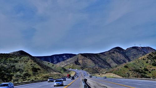 Vehicles on road against mountain range