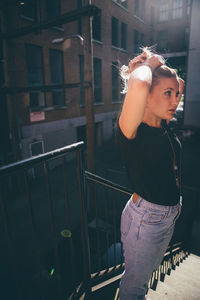 Young woman standing by railing