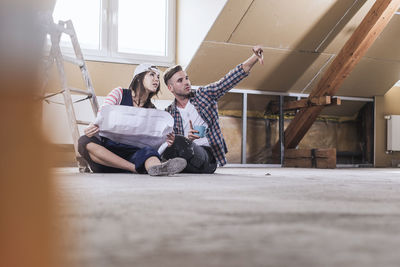 Woman holding blueprint and planning with man for home development