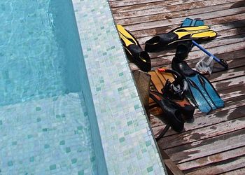 High angle view of diving flippers on boardwalk by swimming pool