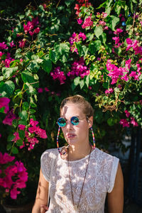 Portrait of man wearing sunglasses against red wall