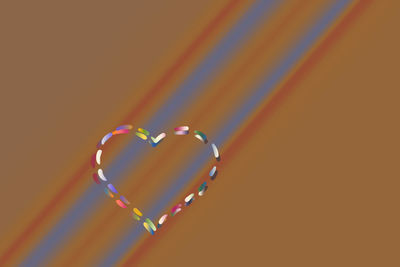 Close-up of heart shape on multi colored background