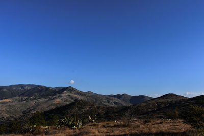 Scenic view of mountains against clear blue sky