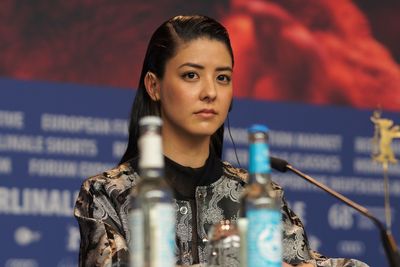 Portrait of young woman standing against city in background