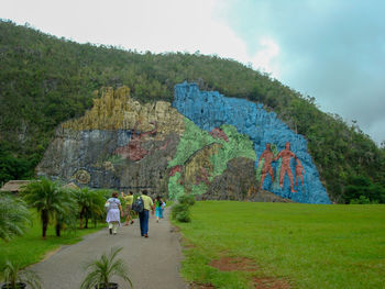 Rear view of people walking on mountain road