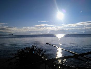 Scenic view of sea against bright sun