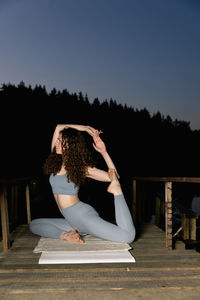 Rear view of woman sitting on table