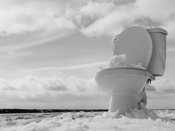 Abandoned commode on snow covered landscape