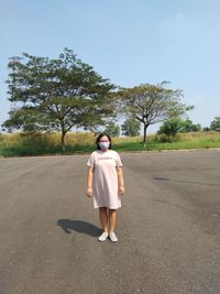 Rear view of woman walking on road against sky