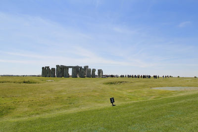 View of stonehenge with green meadow and blue sky on a sunny day in spring, united kingdom