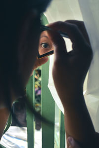 Portrait of woman holding window