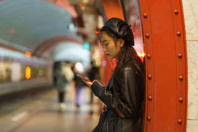 Trendy japanese girl suffer from smartphone and social media addiction miss train at subway platform