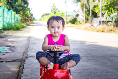 Portrait of cute girl sitting outdoors